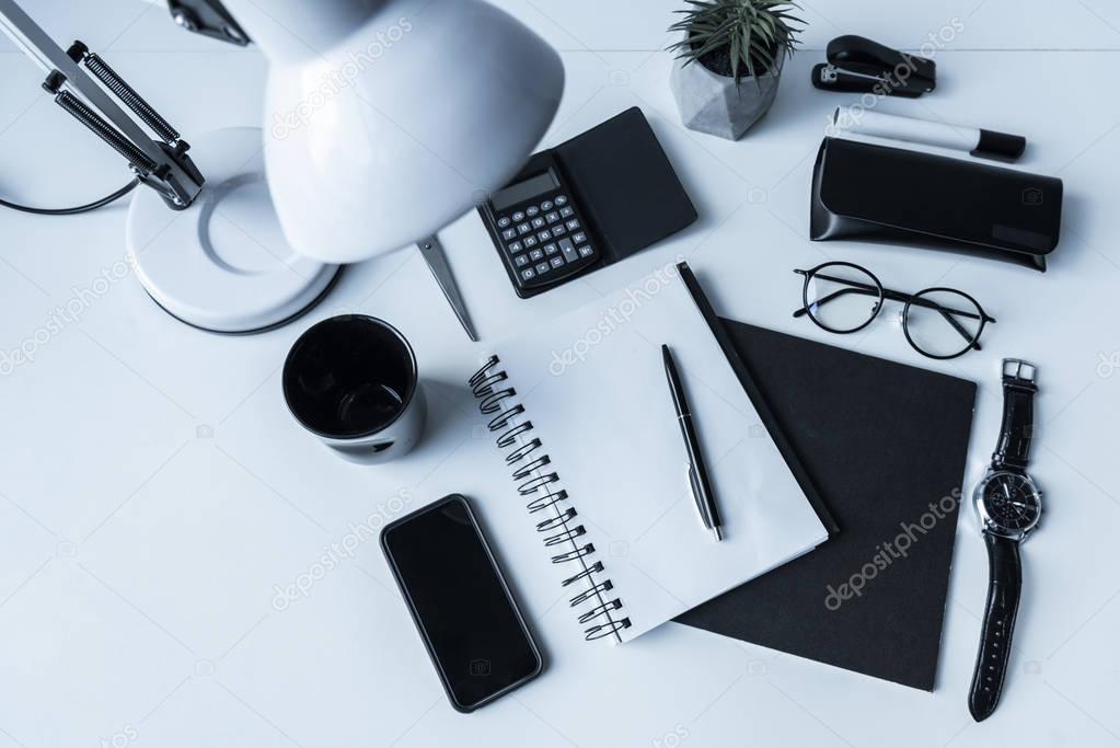 overhead view of working table with smartphone and notebook