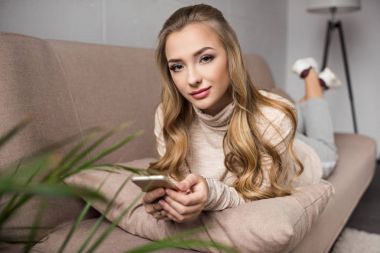 güzel kadın evde kanepede rahat Smartphone kullanarak