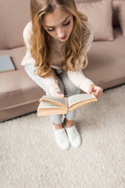 güzel genç kadın evde rahat kanepede kitap okumak yüksek açılı görünüş