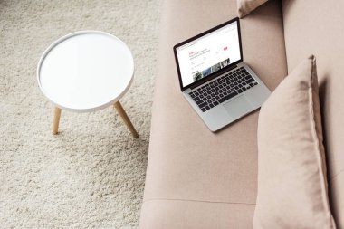 ekranda airbnb Web sitesi ile rahat kanepede dizüstü duran yüksek açılı görünüş