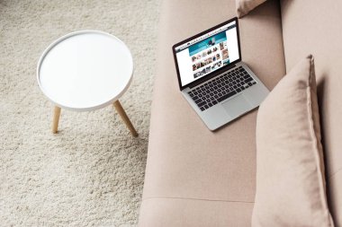 high angle view of laptop standing on cozy couch with amazon website on screen clipart