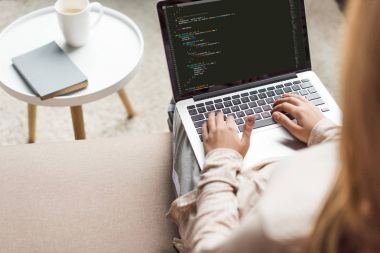 cropped shot of young female developer coding with laptop at home clipart