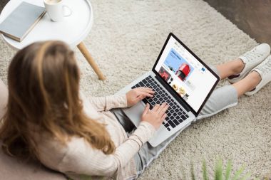 kadının evde yüksek açılı görünüş katta oturan ve dizüstü ekran üzerinde ebay Web sitesi ile kullanma
