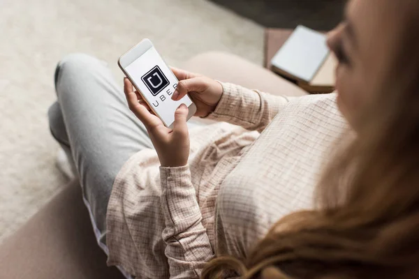 Recortado Tiro Mujer Sofá Con Teléfono Inteligente Con Logotipo Uber —  Fotos de Stock