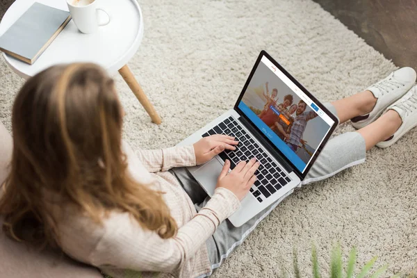 高角度的妇女在家里坐在地板上 并使用笔记本电脑与沙发网站在屏幕上 — 图库照片
