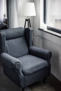 comfortable armchair near window in modern apartment clipart