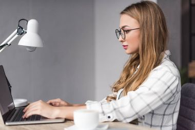 laptop ile işyerinde çalışan genç iş kadını konsantre