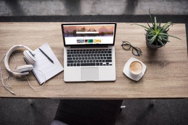 top view of laptop standing at modern workplace with shutterstock homepage website on screen clipart