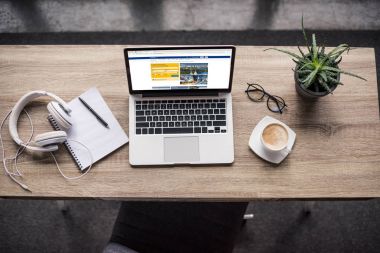 top view of laptop standing at modern workplace with booking website on screen clipart