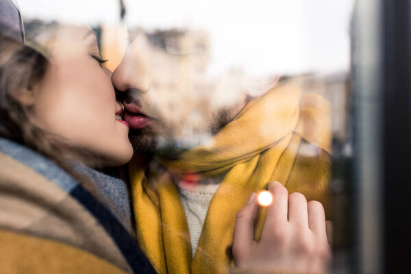 reflective image of kissing couple, closeup