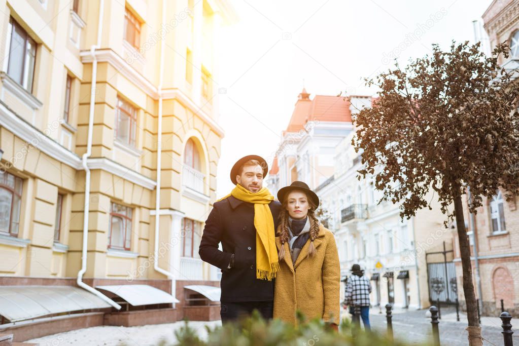 beautiful young couple in autumn outfit on city street