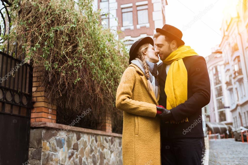 beautiful young couple hugging and kissing at street