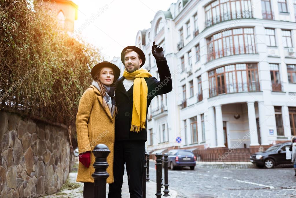 young beautiful couple catching taxi on city street