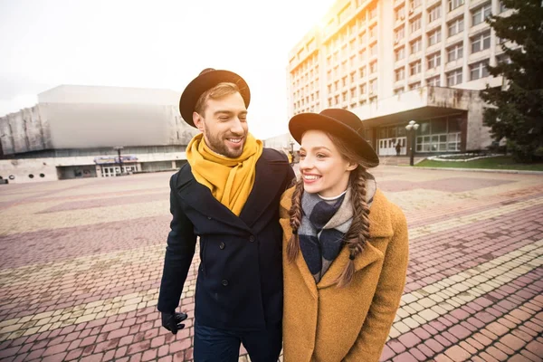 cheerful attractive young couple walking on street