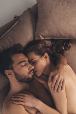 güzel seksi genç çıplak çift yatakta yatmaya  