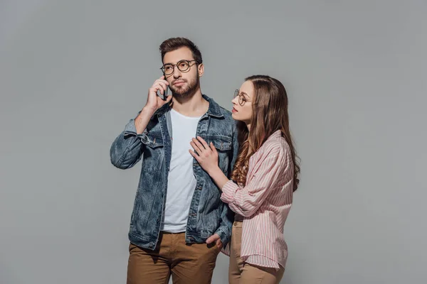 Jonge Vrouw Aanraken Van Stijlvolle Man Brillen Praten Smartphone Geïsoleerd — Stockfoto