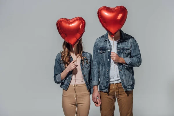 Young Couple Hiding Faces Red Heart Shaped Balloons Isolated Grey — Stock Photo, Image