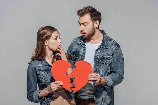 Upset Young Couple Holding Pieces Broken Heart Symbol Isolated Grey — Stock Photo, Image