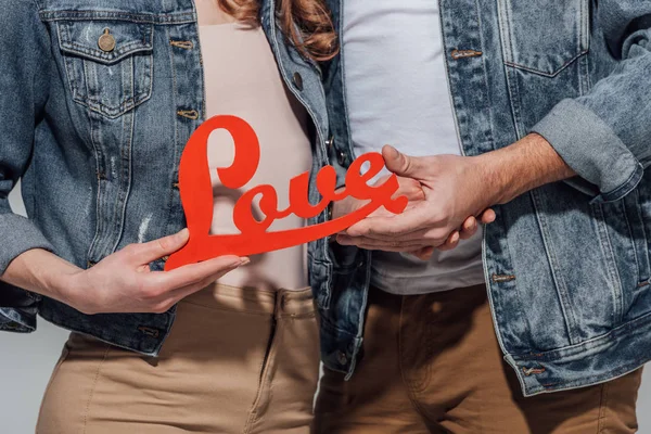 Schnappschuss Eines Jungen Paares Mit Rotem Liebessymbol Isoliert Auf Grau — kostenloses Stockfoto