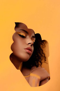 Şehvetli Afro-Amerikan olan kadın sanatsal makyaj ve saç cupcake çerçeve içinde gerbera