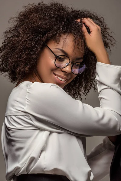 灰色の背景に分離された眼鏡をかけて白いシャツの若い笑顔のアフリカ系アメリカ人女性 — ストック写真
