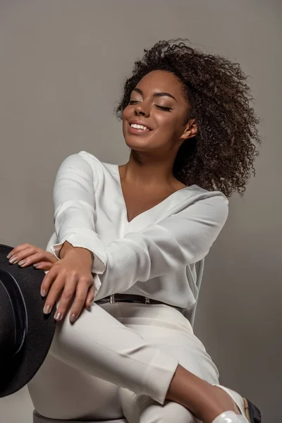 Joven Mujer Afroamericana Sensual Ropa Blanca Sonriendo Sosteniendo Sombrero Negro — Foto de Stock