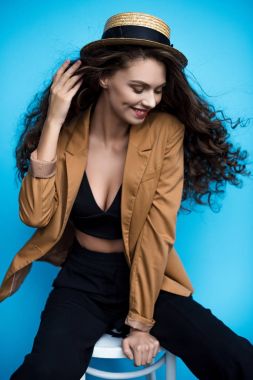 çekici genç kadın şık canotier şapka ve sandalyede oturan ceket