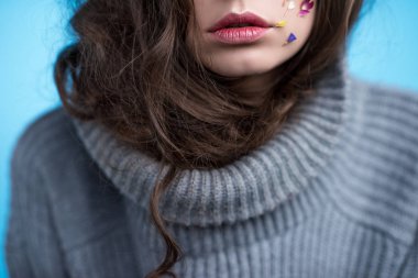 cropped shot of young woman in turtleneck sweater with flowers on face clipart