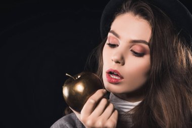 güzel moda genç kadın siyah izole altın elma yiyen