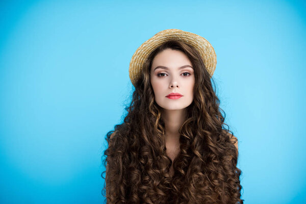 красивая молодая женщина в каноэ шляпа на длинные кудрявые волосы изолированы на синий
