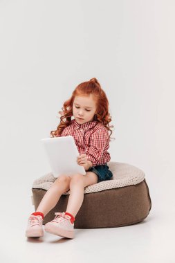 sevimli küçük çocuk oturma ve dijital tablet gri izole kullanma