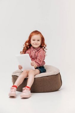 Dijital tablet tutarak ve gri izole kamera gülümseyen sevimli küçük çocuk