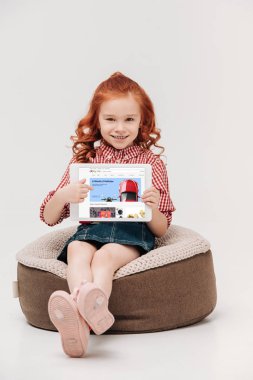 ekranda gri izole dijital tablet ebay Web sitesi ile tutarak kameraya gülümseyen sevimli küçük kız