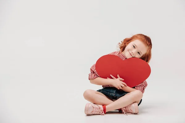 Schattig Kindje Knuffelen Rood Hartsymbool Lachend Camera Geïsoleerd Grijs — Stockfoto