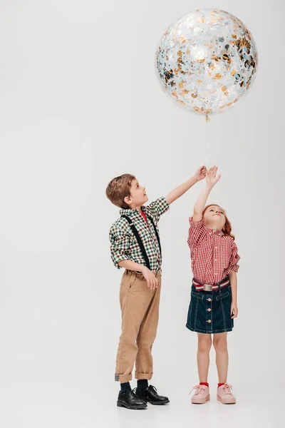 可爱的小孩子抱着闪亮的气球在灰色的隔离 — 图库照片
