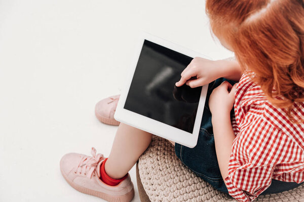 cropped shot of redhead child using digital tablet with blank screen isolated on grey