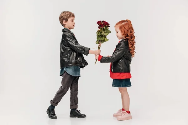 Schöner Kleiner Junge Überreicht Rosenstrauß Seine Freundin Isoliert Auf Grau — Stockfoto