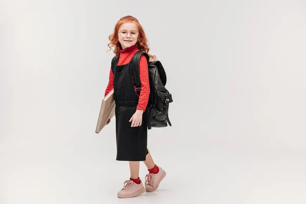 Colegiala Sonriente Con Mochila Gran Libro Mirando Cámara Aislada Gris — Foto de Stock