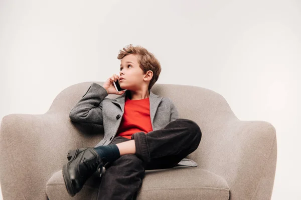 Stylish Little Boy Talking Phone While Sitting Comfy Armchair Isolated — Free Stock Photo