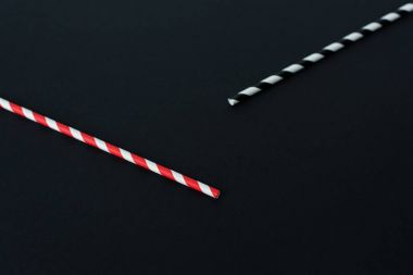 close-up view of striped drinking straws isolated on black clipart