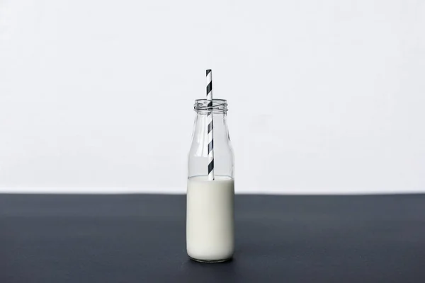 Γυάλινο Μπουκάλι Γάλα Και Ριγέ Πόσιμο Άχυρο Γκρι — Φωτογραφία Αρχείου