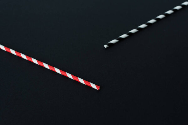 close-up view of striped drinking straws isolated on black