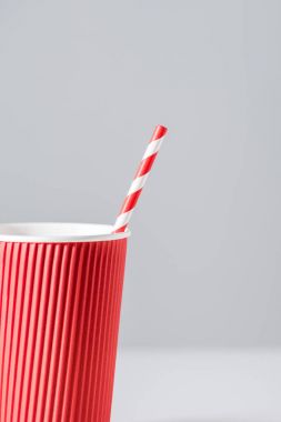 close-up view of red paper cup with drinking straw isolated on grey clipart