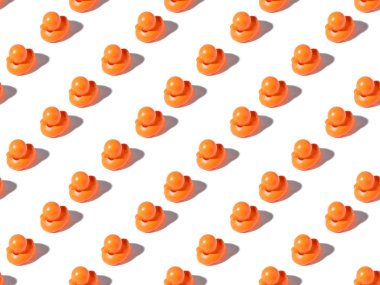seamless pattern of small orange rubber ducks on white  clipart