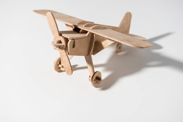 close-up view of small wooden toy plane on white