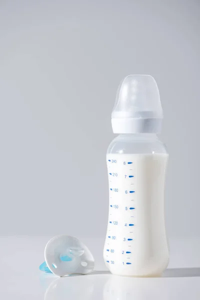 Nahaufnahme Einer Plastikflasche Mit Milch Und Brustwarze Auf Grau — Stockfoto