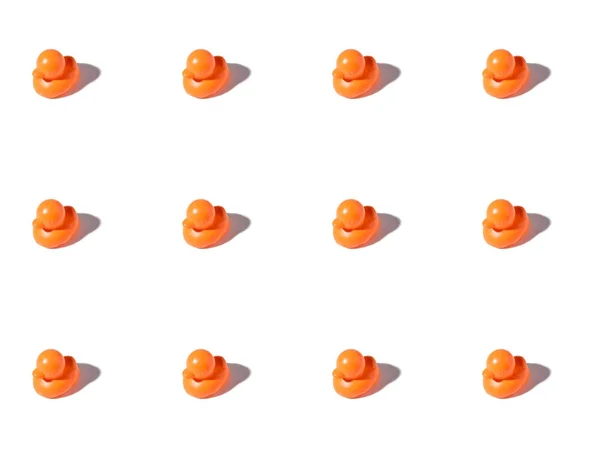 Fondo Con Pequeños Patos Goma Naranja Sobre Blanco — Foto de Stock