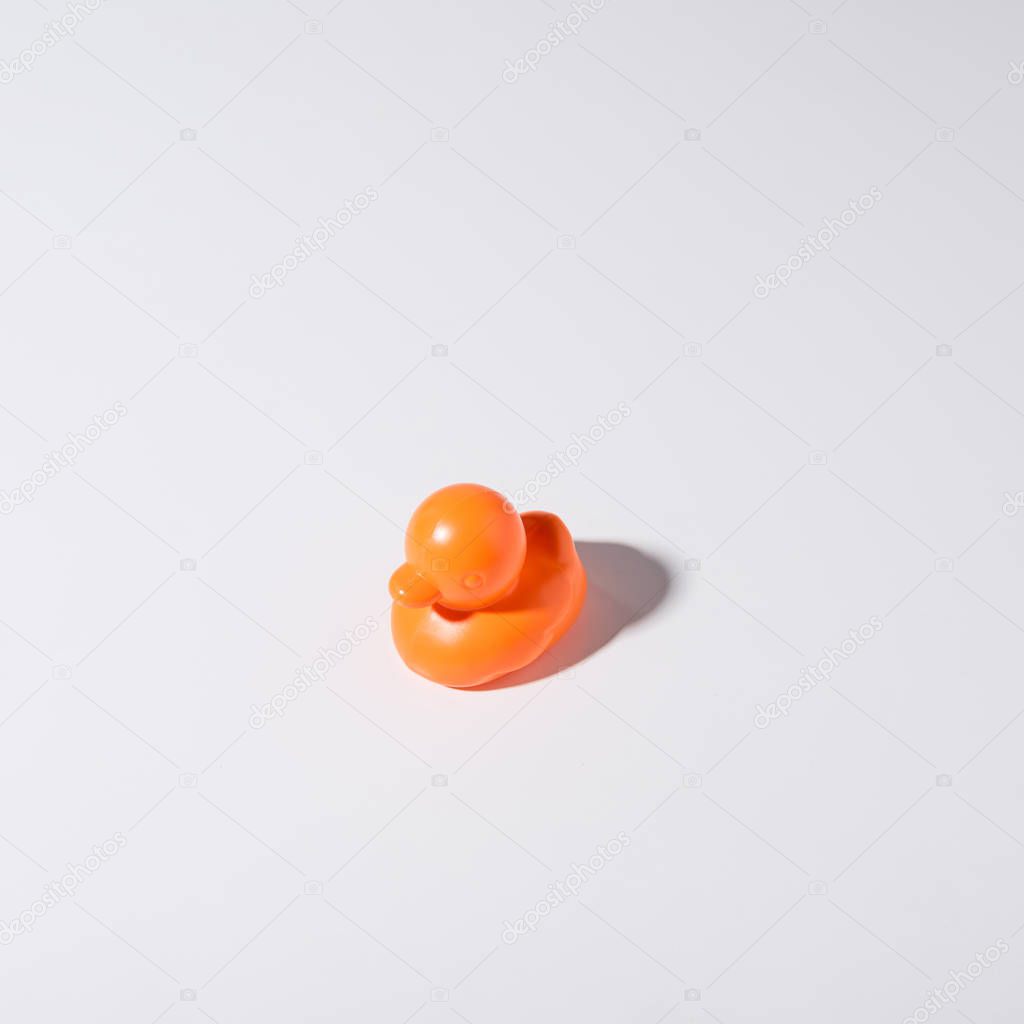 close-up view of one orange rubber duck isolated on grey