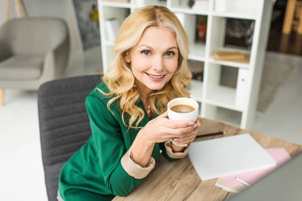 Piękne Dojrzałe Bizneswoman Gospodarstwa Filiżankę Kawy Uśmiecha Się Kamery — Zdjęcie stockowe