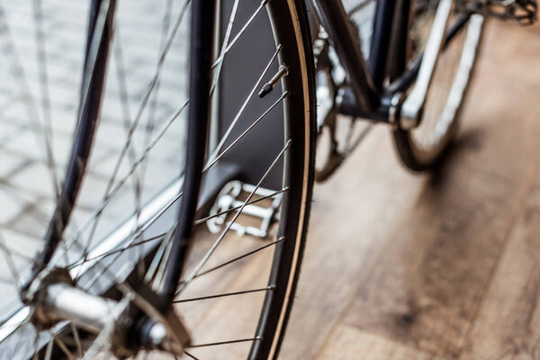 cropped image of bicycle on wooden floor in house